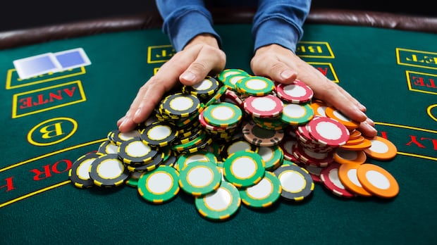 A poker player pushes chips into the centre of a table.