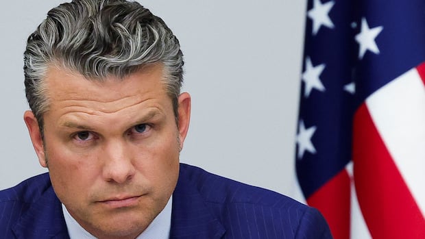U.S. Secretary of Defence Pete Hegseth attends a meeting of the Ukraine Defence Contact Group, after a meeting of NATO Defence Ministers at the Alliance headquarters, in Brussels, Belgium October 15, 2025. A man looking forward, with a U.S. flag seen in the background