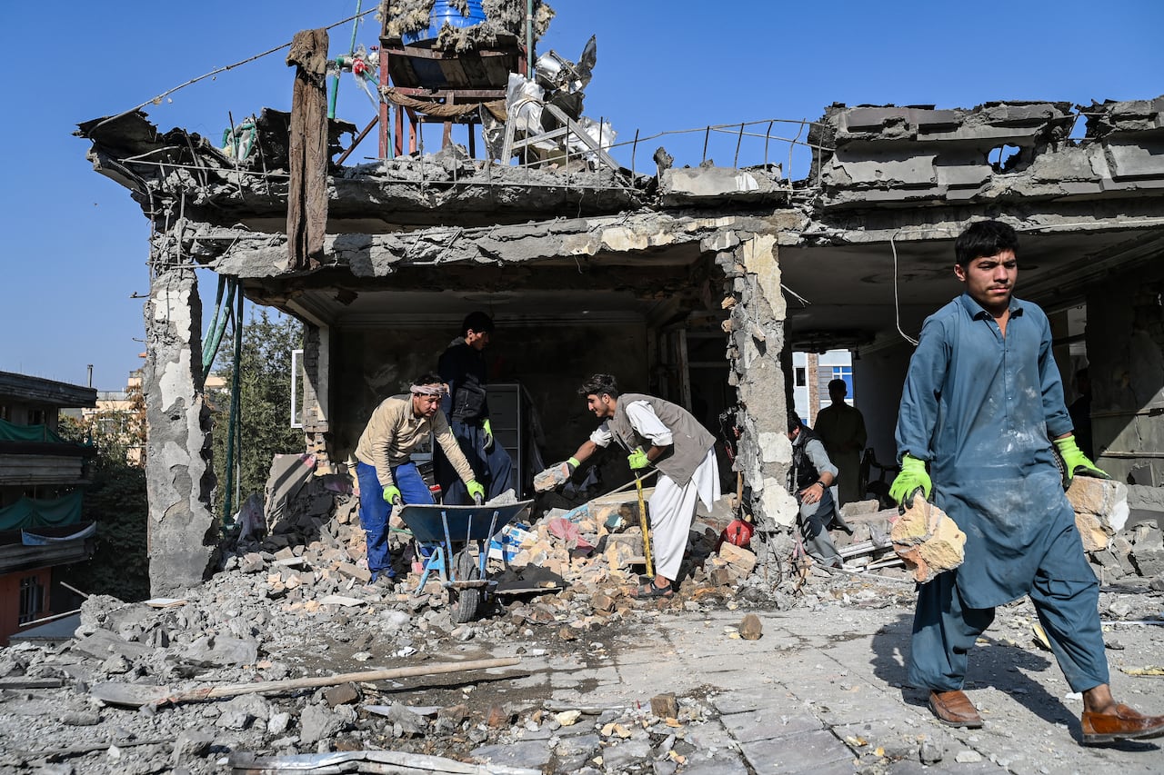 People are clearing the debris from the area of the destroyed house.