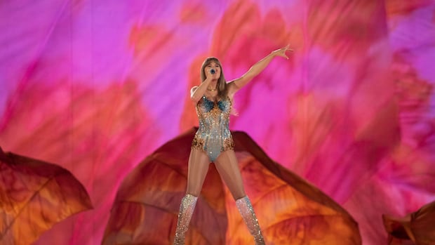 A woman is pictured in a sparkly bodysuit on a stage. 