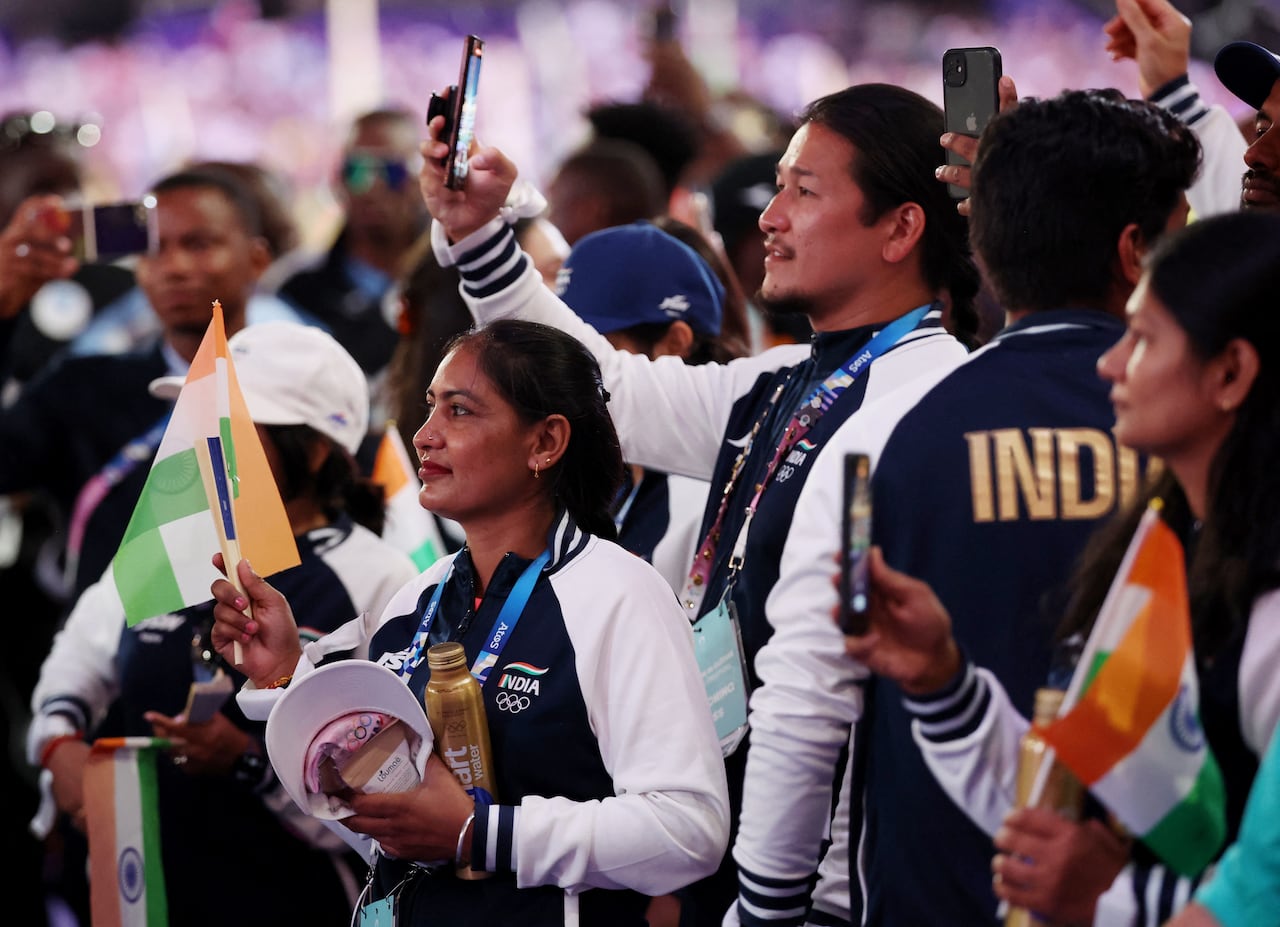 人們穿著印有“印度”字樣的配套夾克,舉著旗幟和電話。