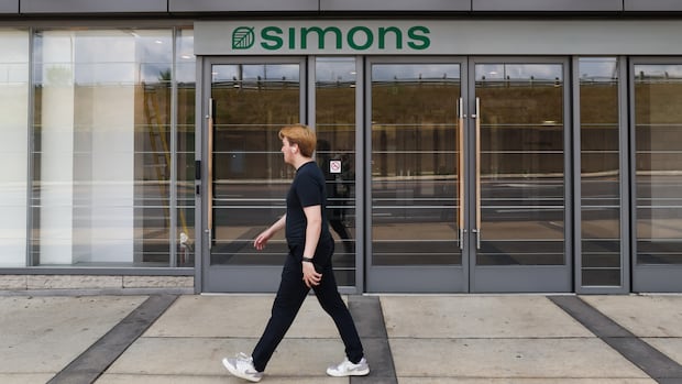 A man is walking outside the newly opened Simons