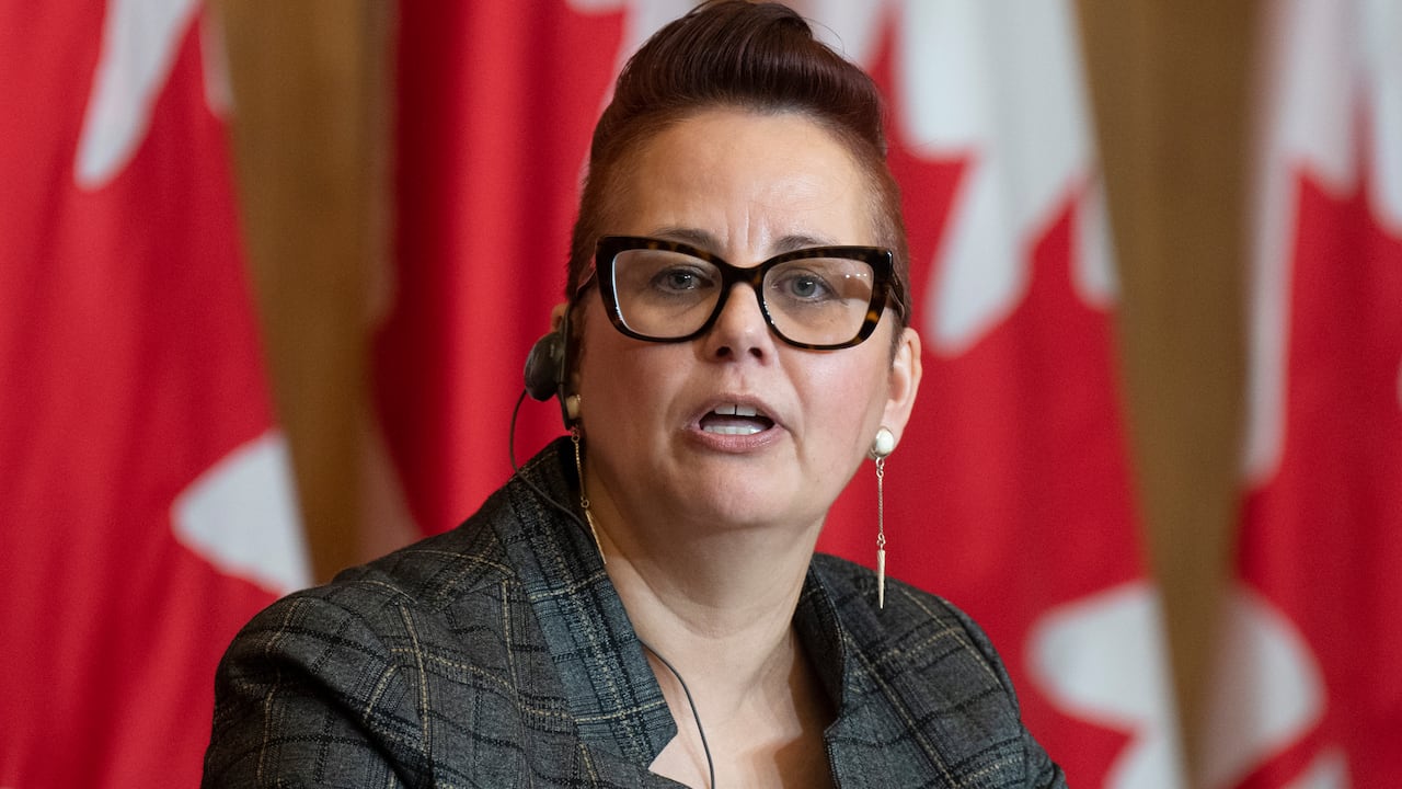 Close-up of Anderson with Canadian flags behind her