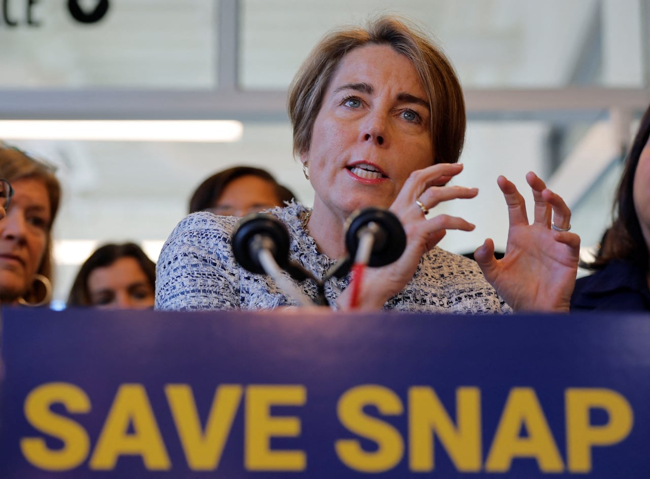 A woman with ear-length hair touches the motion of the shot while speaking on a podium with a space in front saying, "Save the snap."
