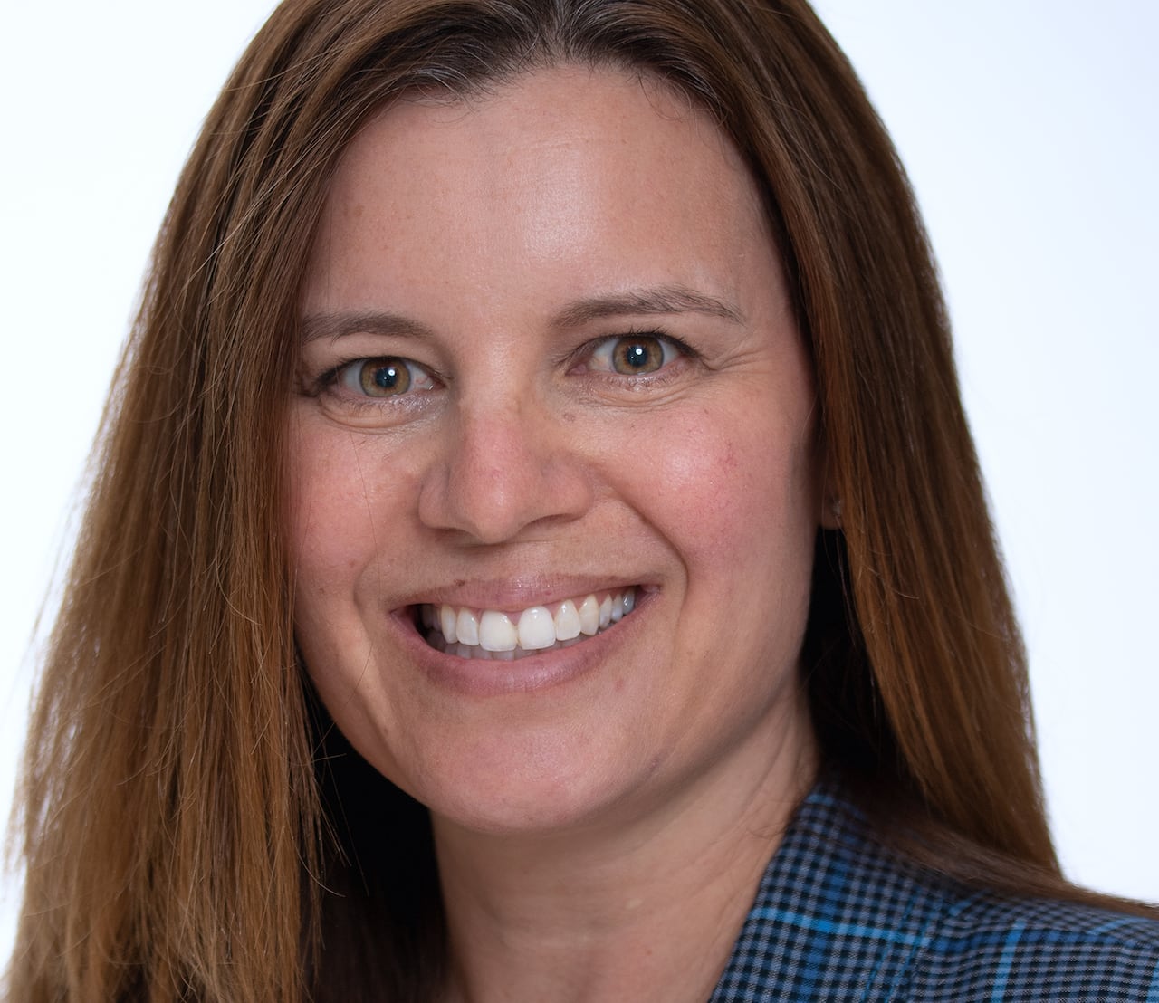 a woman in a blue plaid blazer smiles at the camera in a headshot photo