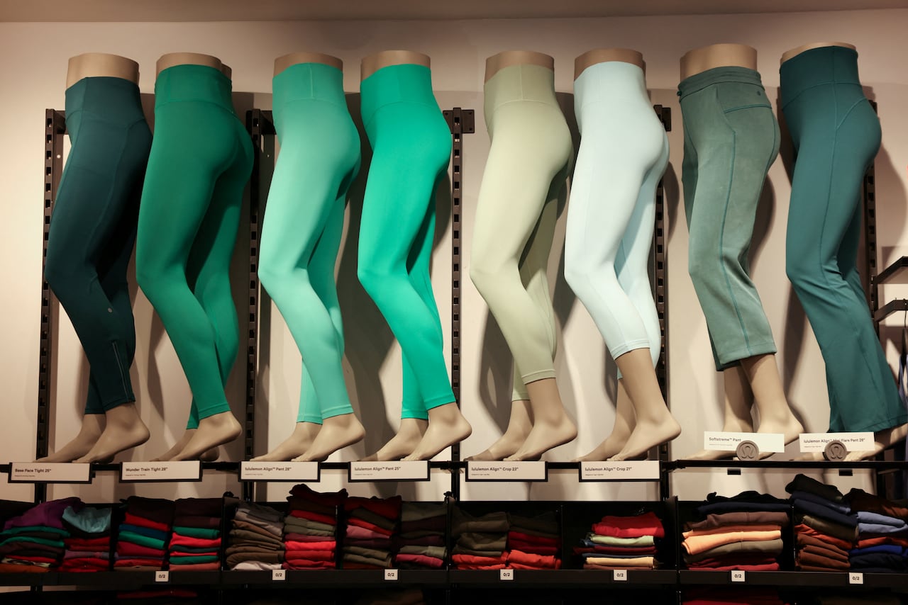 vari modelli di pantaloni verdi Lululemon sono esposti su manichini in un negozio