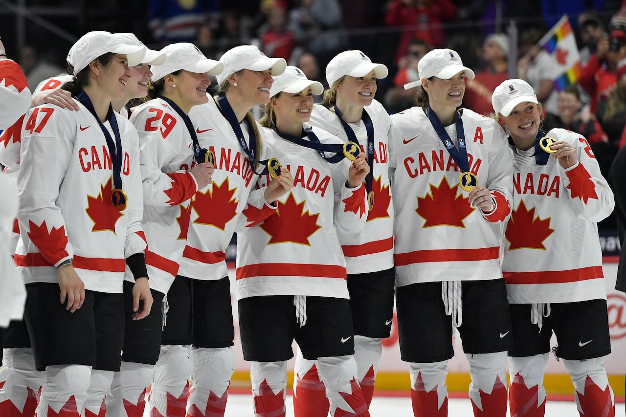 Hockey players pose with their gold medals.