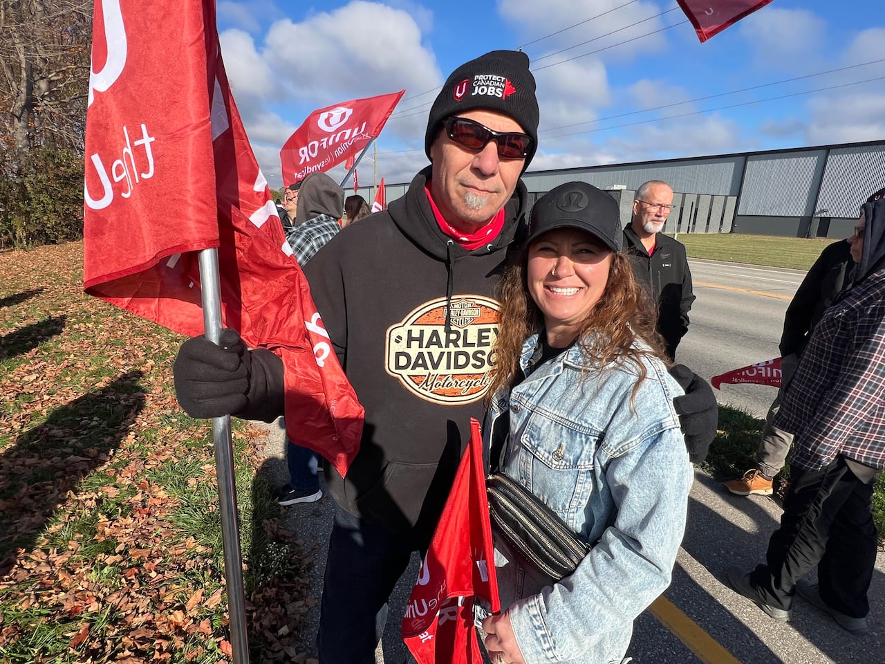 Two people standing together holding a sign