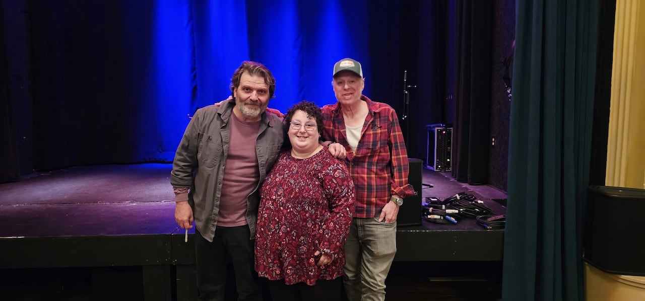 A pistillate stands betwixt 2 men, with a signifier down them.