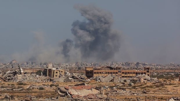 Smoke rises from a destroyed city