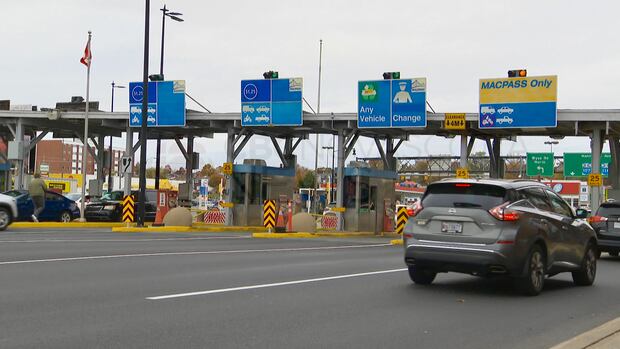 cars drive up to a toll booth