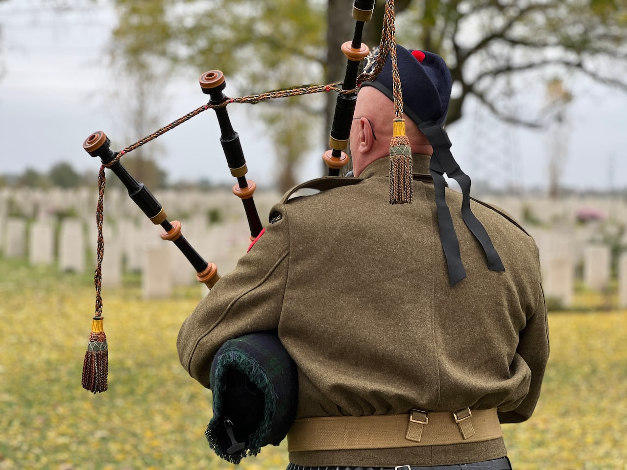 A man plays a pipe from a bag
