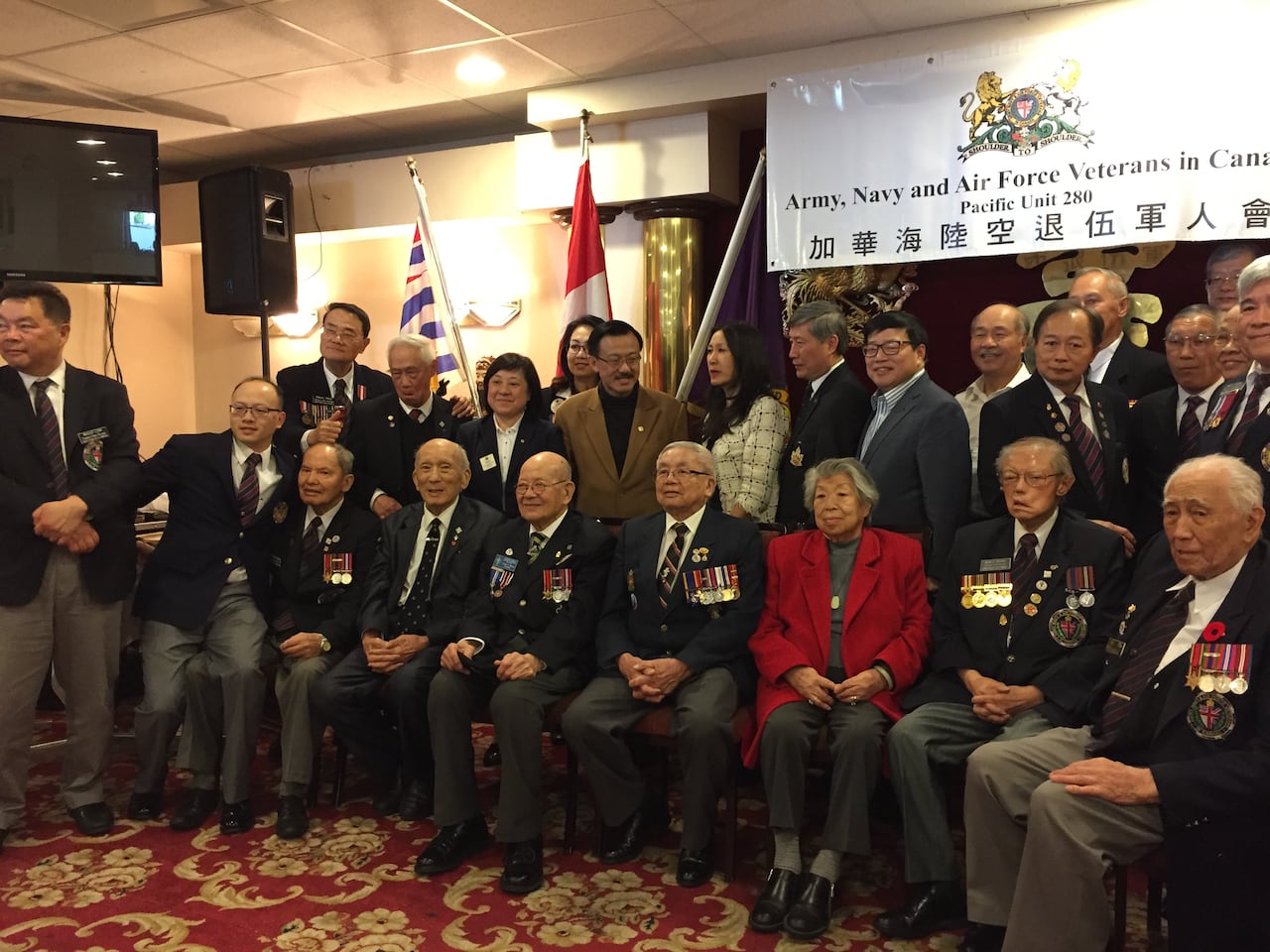 A group of men and women in army attire are pictured.