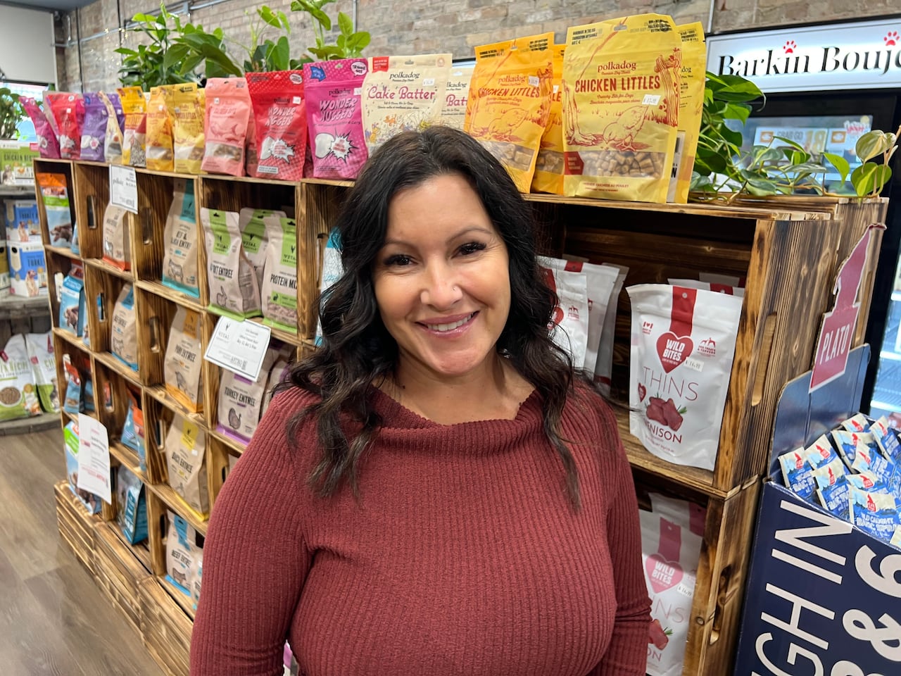 A woman stands in her pet food store