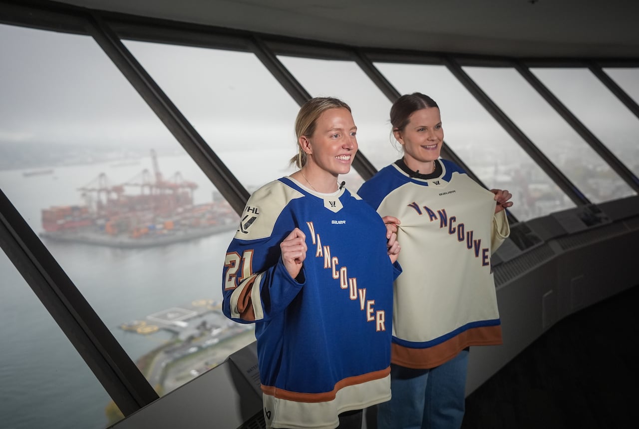 Two women are lasting successful beforehand of a model and wearing Vancouver hockey jerseys