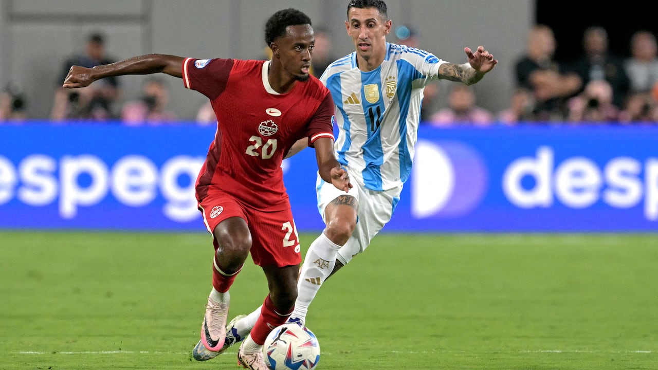 A soccer player runs with the ball.