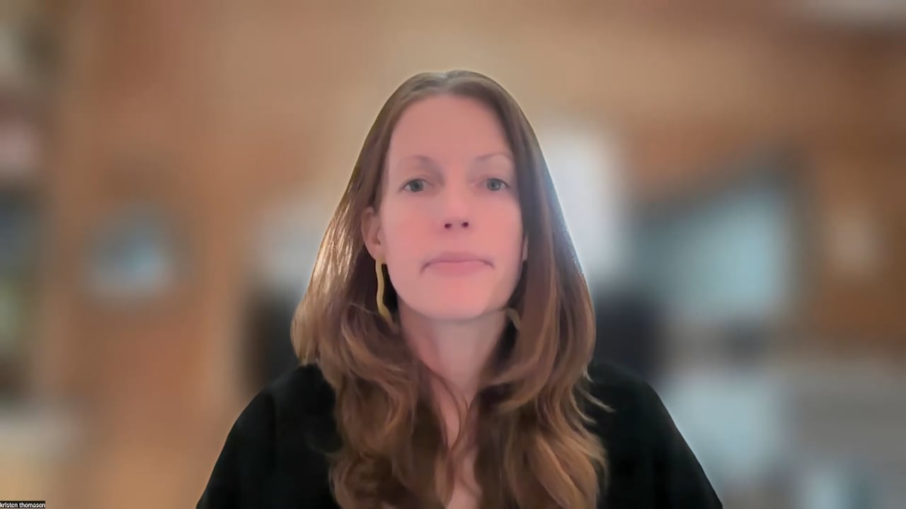 A person stares straight forward with a blurred background.