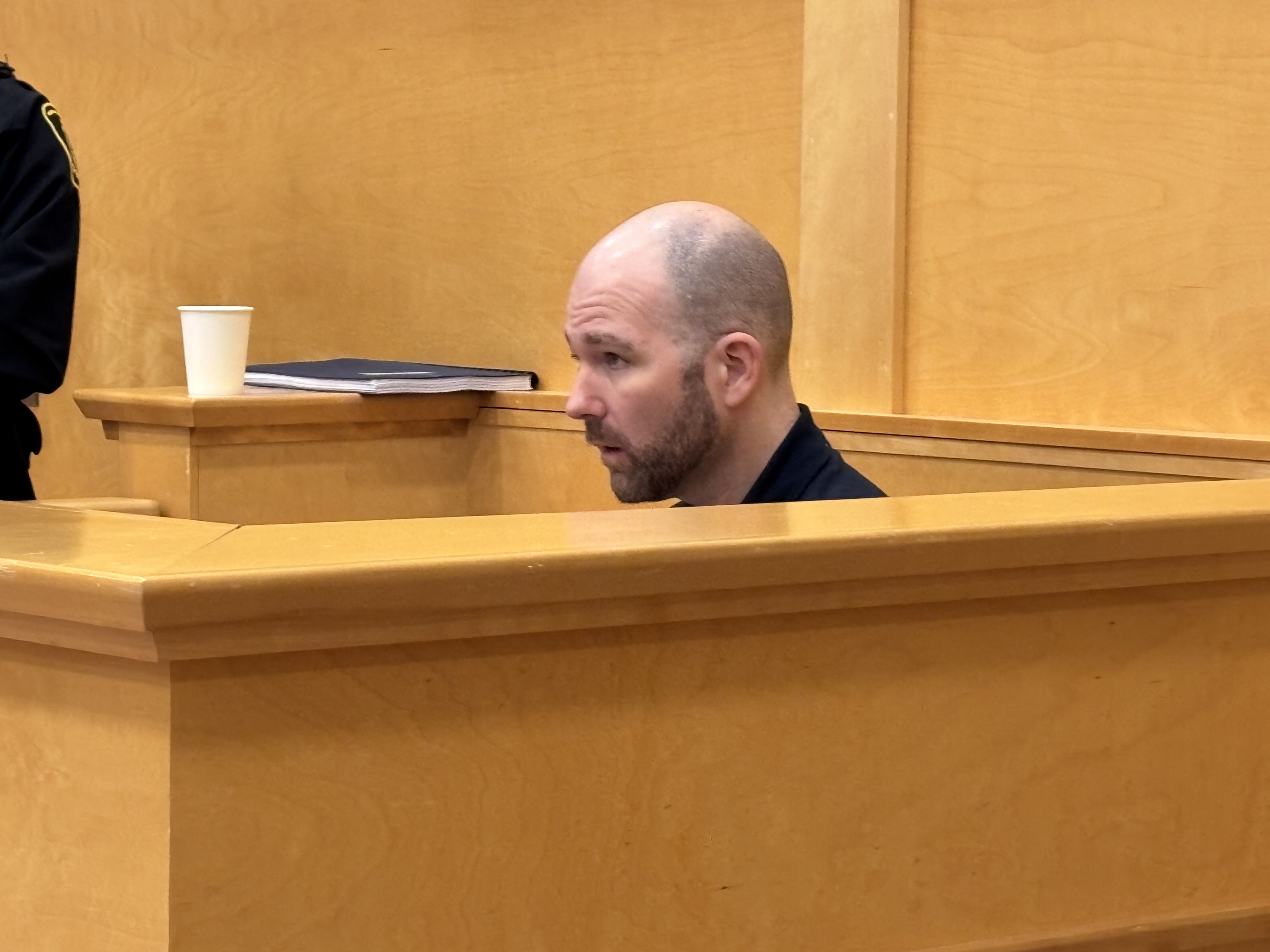 Murder trial underway for Deer Lake's Justin Paul Campbell, accused of strangling grandmother; A man sitting in a courtroom box\.