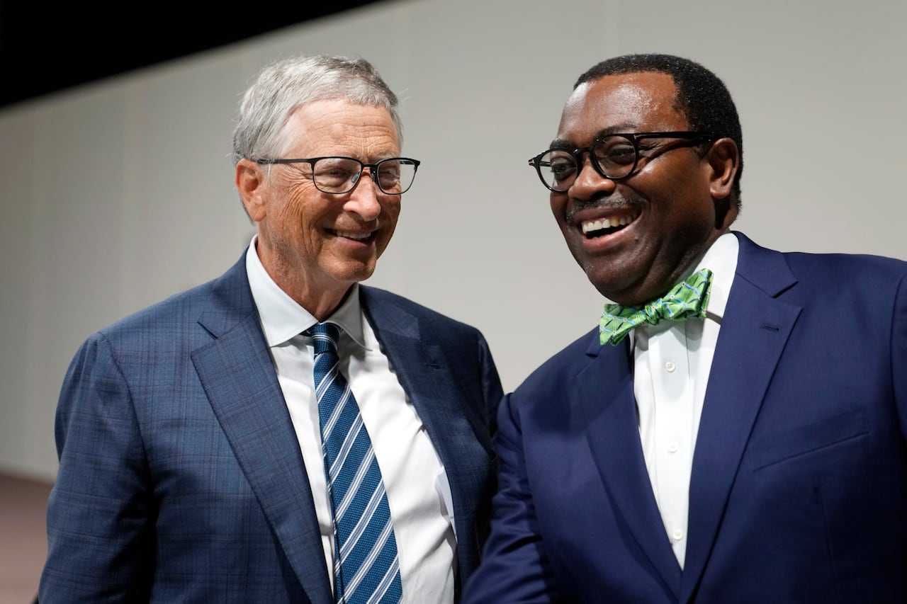 The two men are smiling and shaking hands.