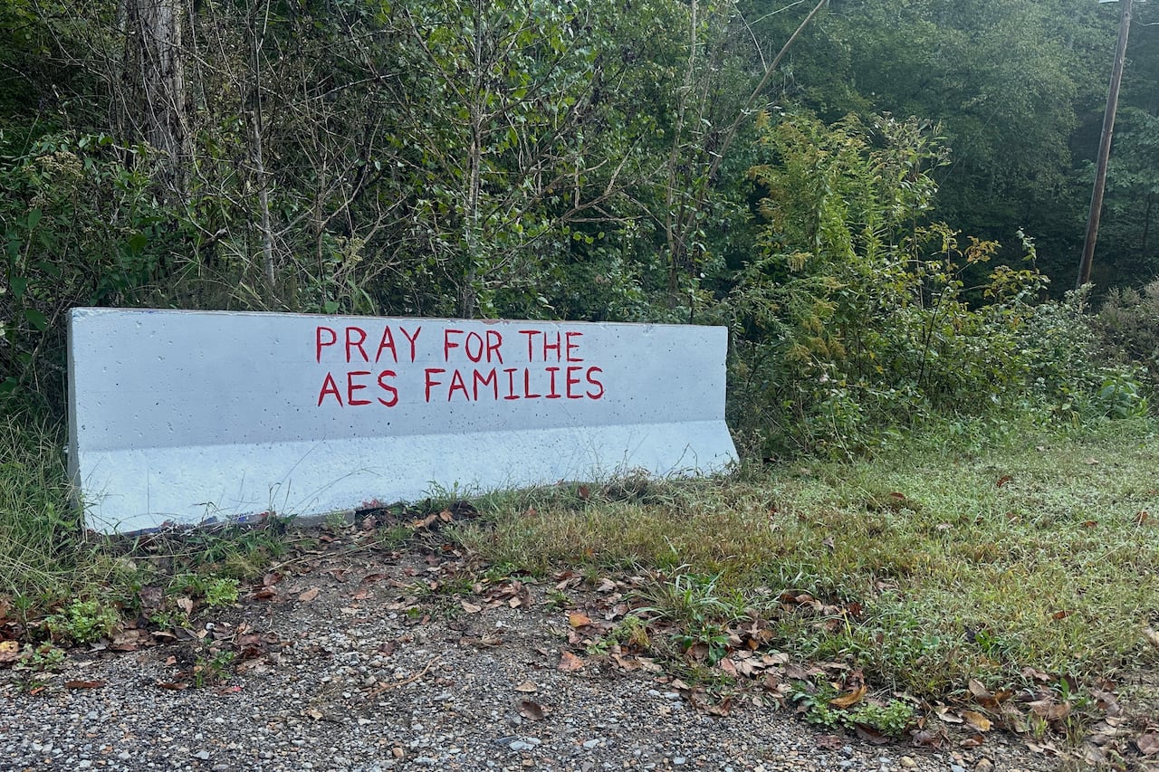 “為 AES 家庭祈禱”的字樣寫在混凝土路障上。