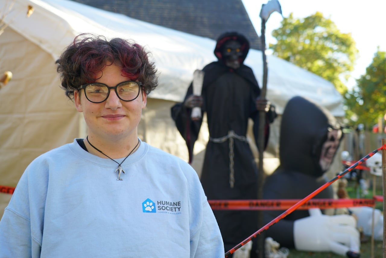 Zander Waller stands in front of his Halloween walk-through display.