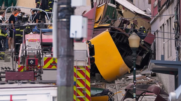 Emergency teams work at the site of a derailed electric streetcar in Lisbon, Portugal.