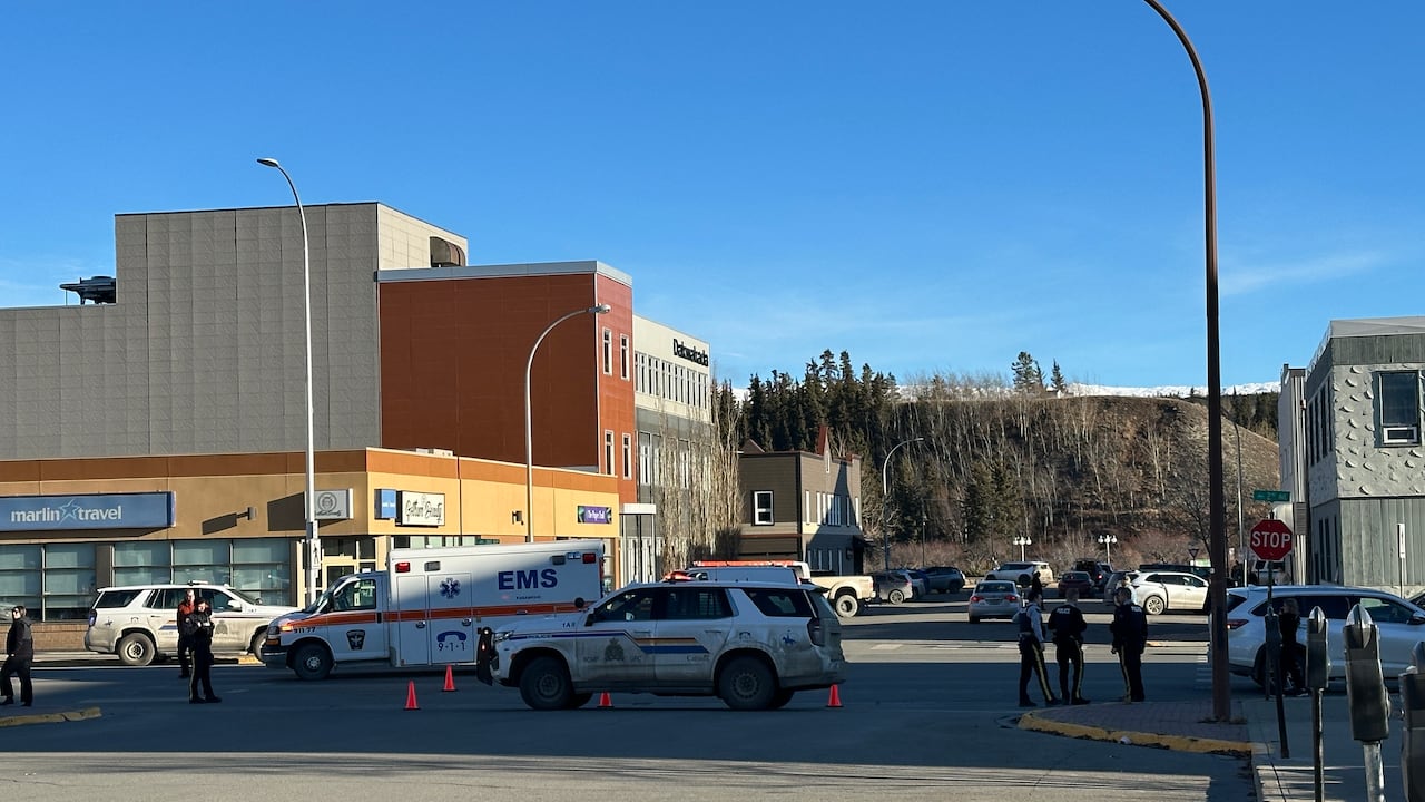 Police vehicles, and an ambulance in the middle of a busy intersection.
