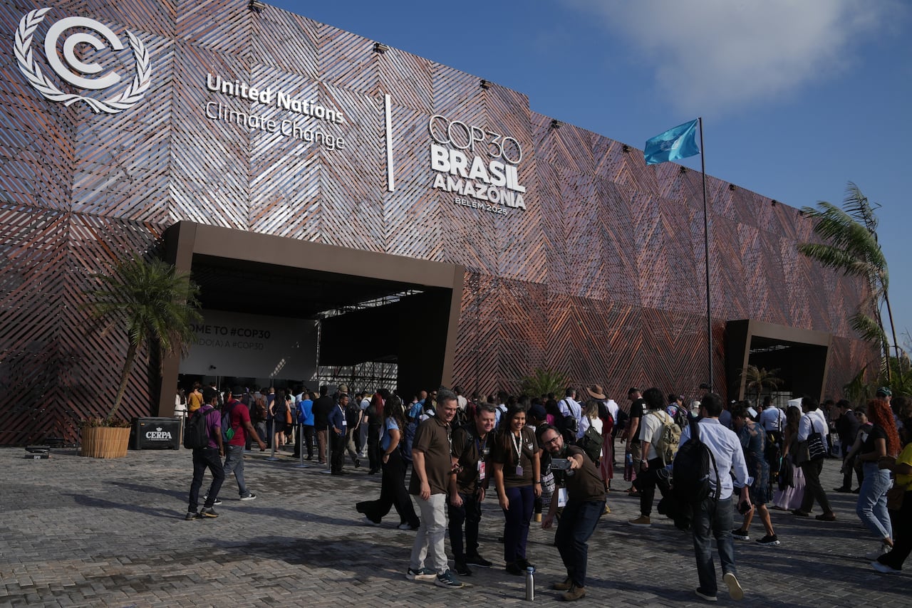 People pose for pictures outside the Cop30 climate summit, Monday, November 20, 2025, in Belem, Brazil. (AP Photo / Fernando Llano)