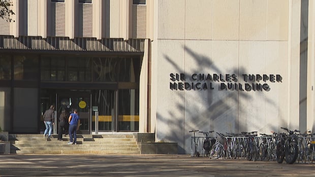 Students walk into a university building.