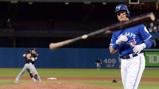 A baseball player tosses his baseball bat