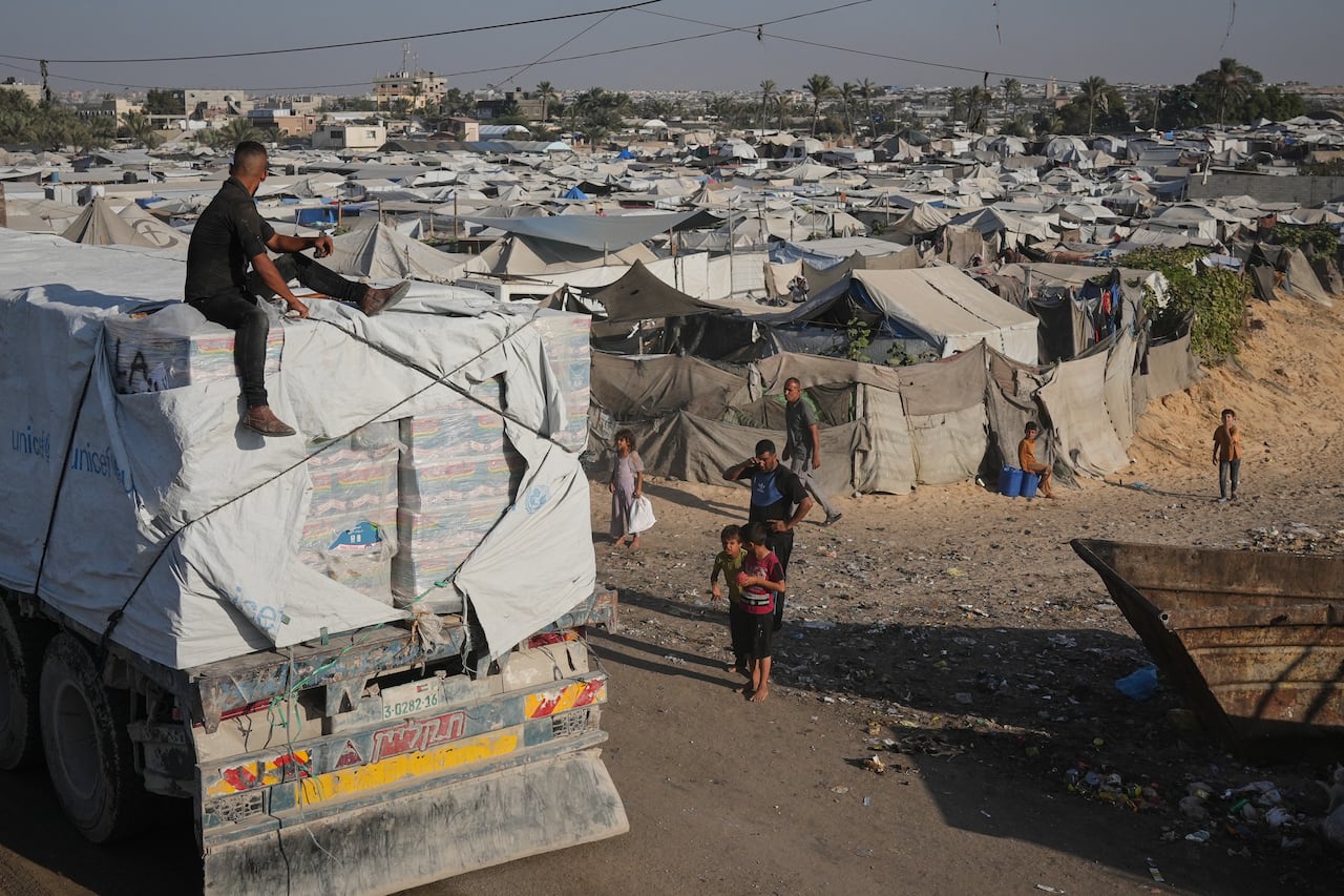A person lives in a village where people gather in a tent camp.