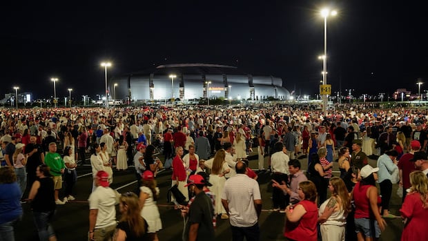 People arrive, ahead of the morning sunlight, to attend a memorial service for slain conservative commentator Charlie Kirk at State Farm Stadium