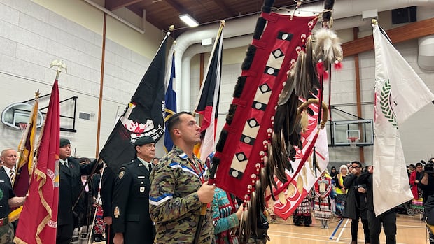 Several people are seen, with several in military uniforms, in a gym 