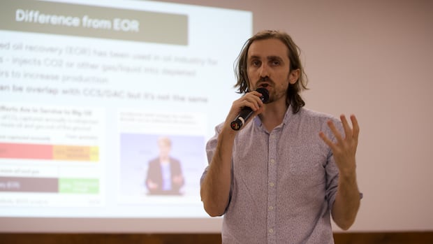 A man stands holding a mic.