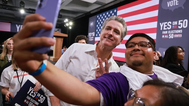 Gov. Gavin Newsom meets with attendees during a campaign event on Proposition 50, Nov. 1, 2025, in Los Angeles. Two men pose for a selfie