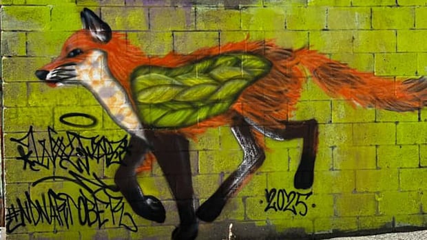 Graffitied fox on a brick wall