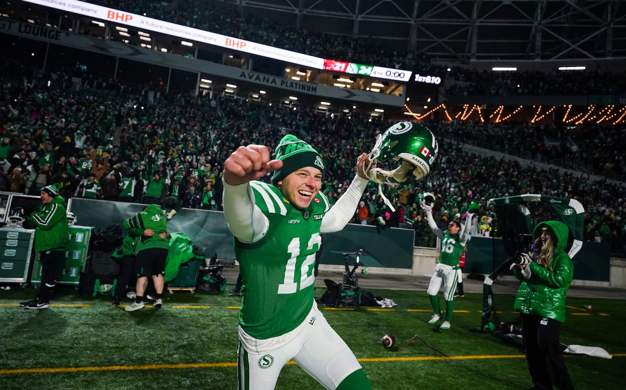 A man in a green jersey celebrates in the stadium field.