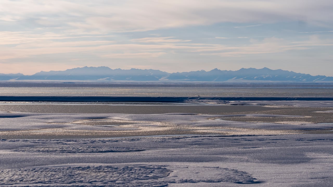 Ice and water with mountains in the background.