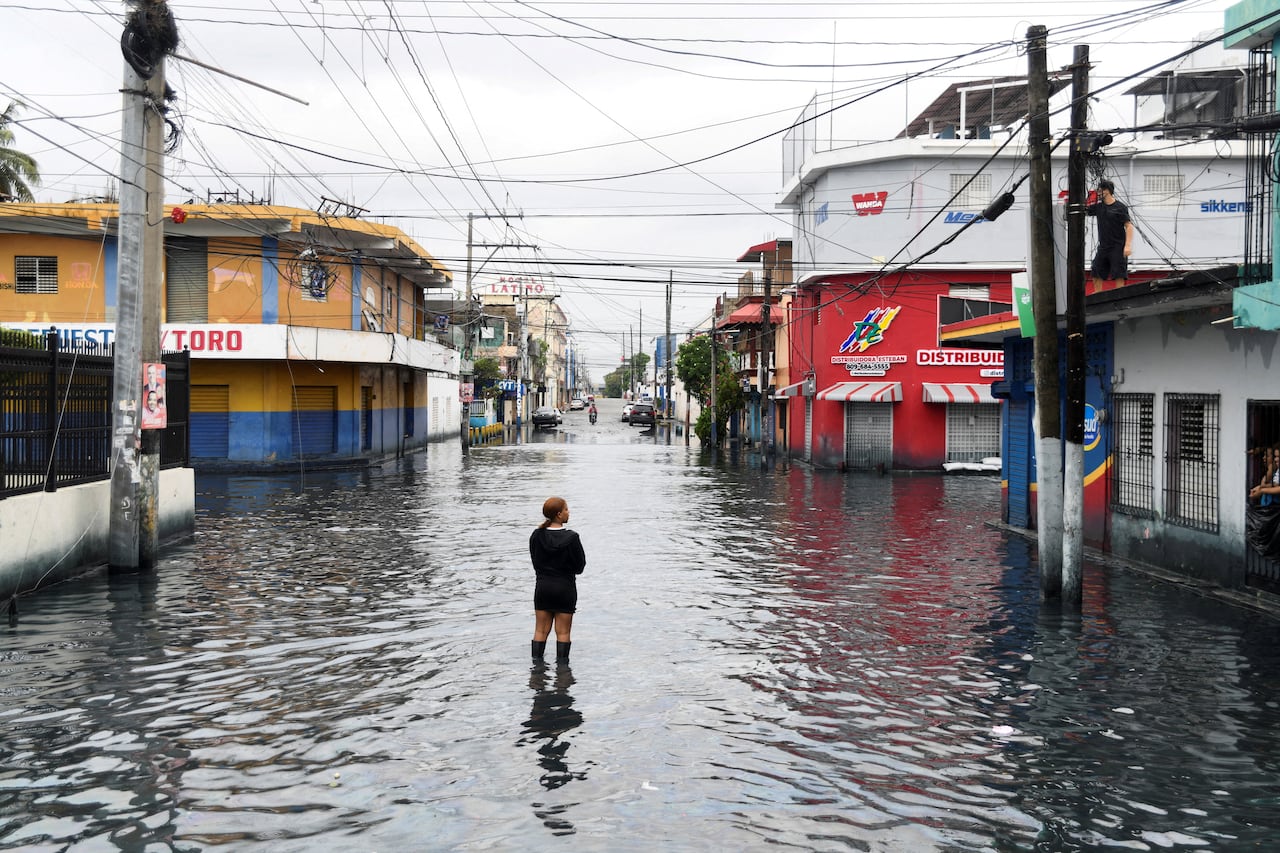 A person stands in a flooded street.