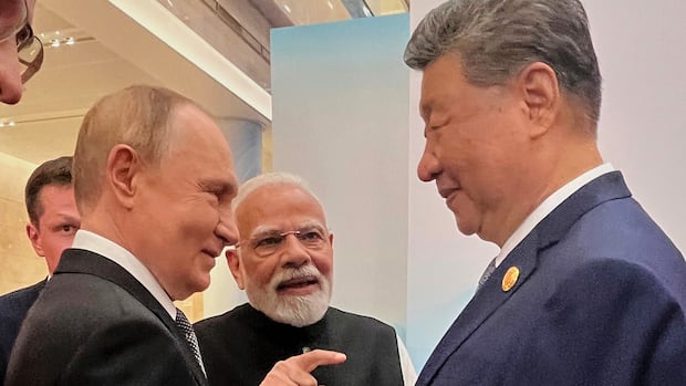 Three men wearing suits gathered together. 
