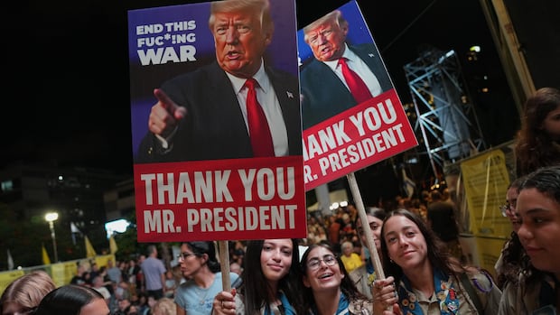 People hold up signs showing a man and the text: 'End this fuc*!ng war' and 'Thank you Mr. President.'
