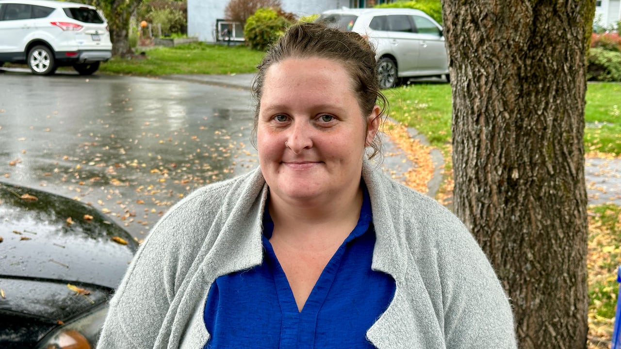 A woman in a blue shirt smiles at the camera. 