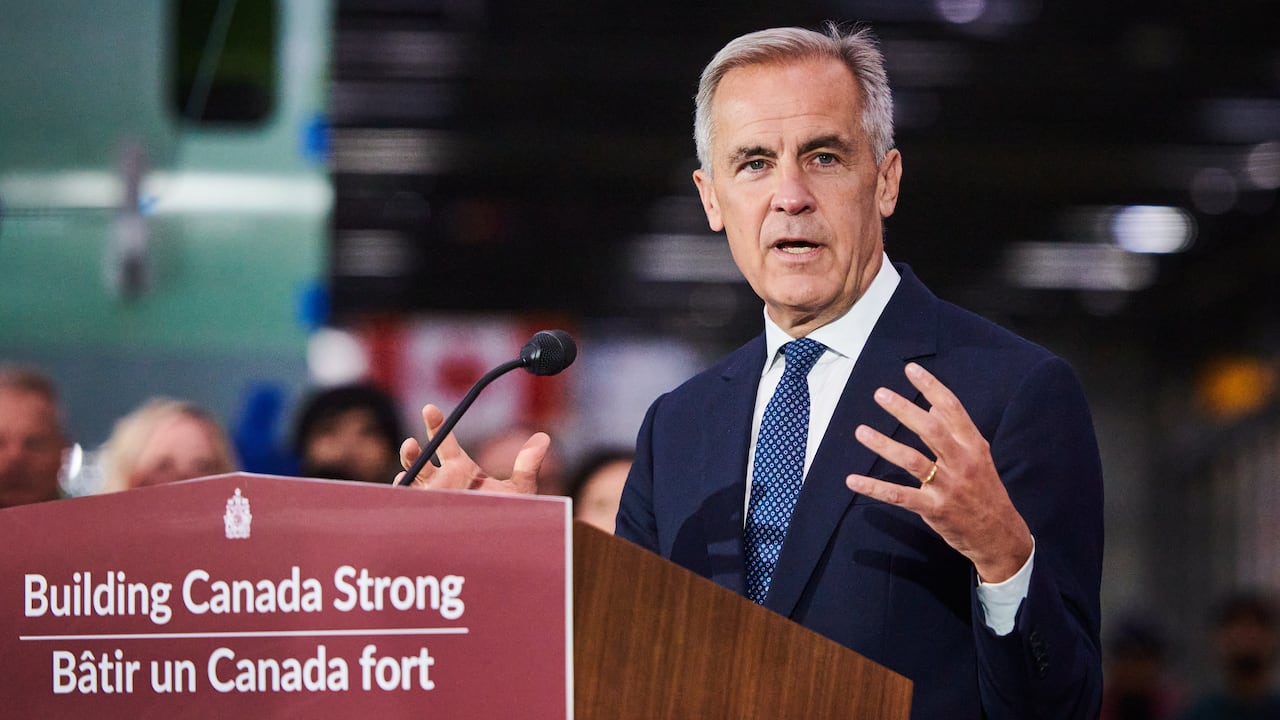 Prime Minister Carney speaking from podium in a factory