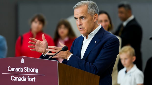 A man gestures while standing at a podium