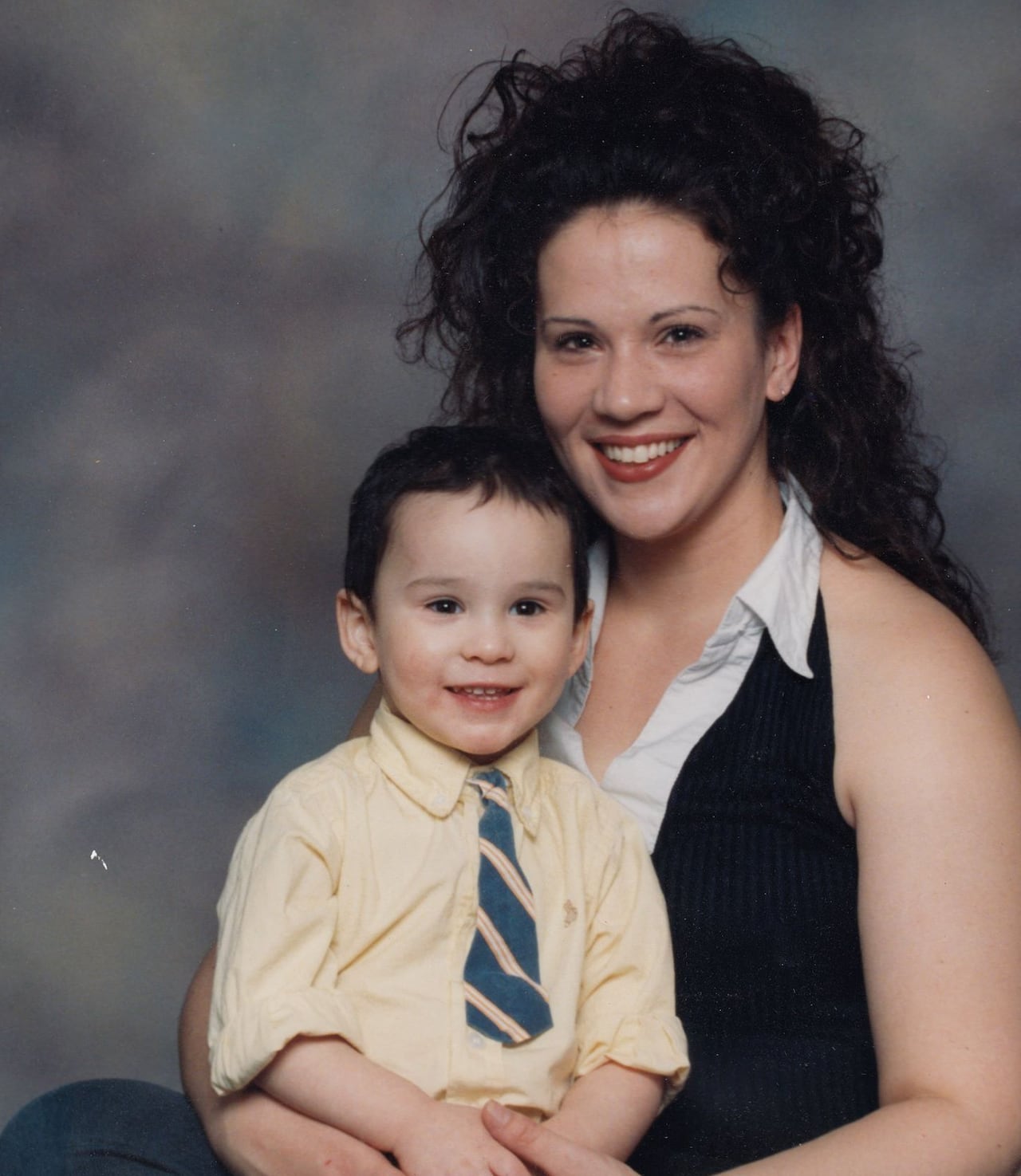 A young mother holding her son in her lap for a portrait photo
