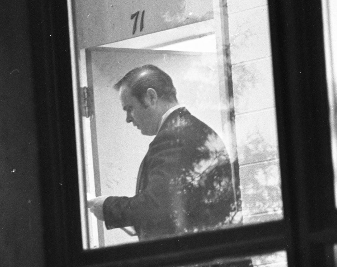 A police officer stands outside Classroom 71, in the hallway where Robert Poulin shot himself, on Oct. 27, 1975.