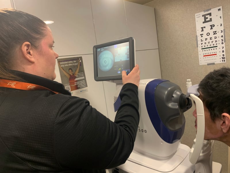 A woman operates a machine with a photo of an eye.