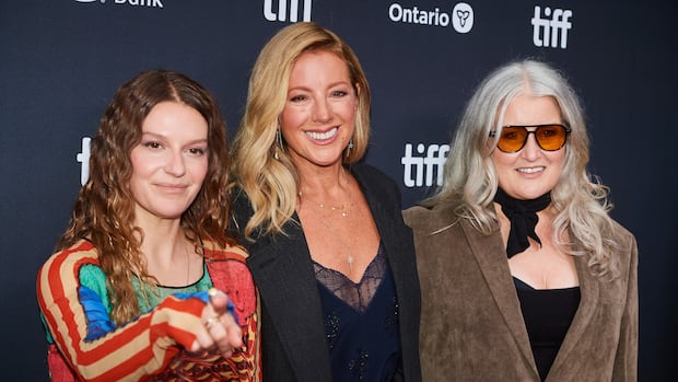 Three women smile in front of a black backdrop with 'tiff' branding.