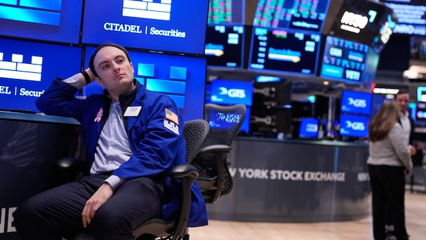 Joseph Maguire works on the floor at the New York Stock Exchange in New York, Tuesday, Nov. 11, 2025. A man sits amid the monitors and desks of a stock exchange, looking off camera.