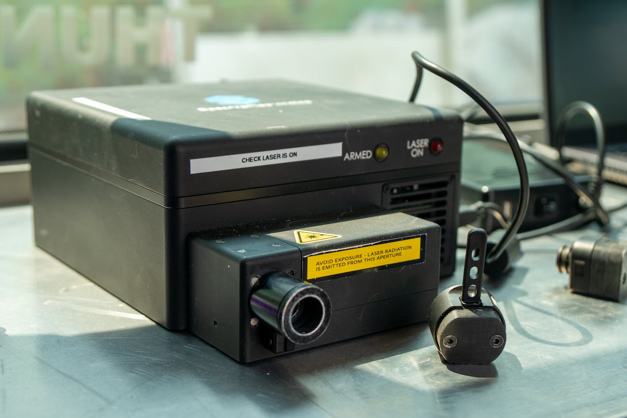 A close-up of a tiny achromatic scanning instrumentality connected a table.